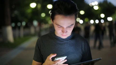 Man sms texting using app on smart phone at night in city.  Stock Footage 90757622