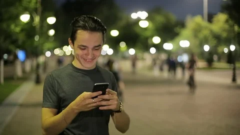 Man sms texting using app on smart phone at night in city.  Stock Footage 90762648