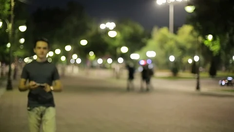 Man sms texting using app on smart phone at night in city.  Stock Footage 90771617