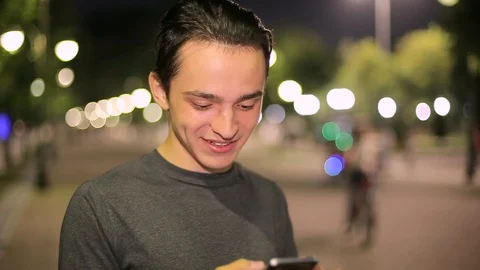 Man sms texting using app on smart phone at night in city.  Stock Footage 90772812