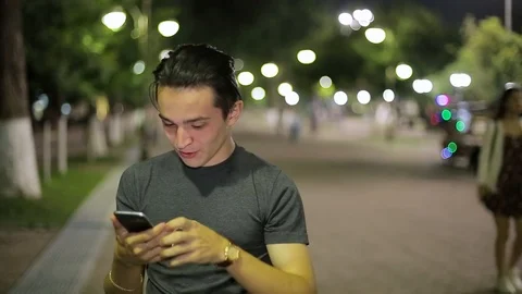 Man sms texting using app on smart phone at night in city.  Stock Footage 90773541