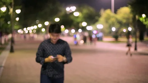 Man sms texting using app on smart phone at night in city. Stock Footage 90776169