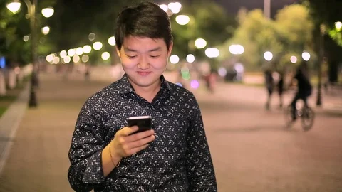 Man sms texting using app on smart phone at night in city. Stock Footage 90777412