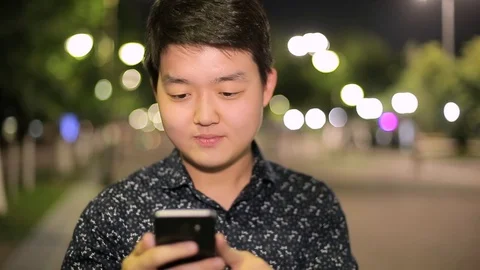 Man sms texting using app on smart phone at night in city. Stock Footage 90778756