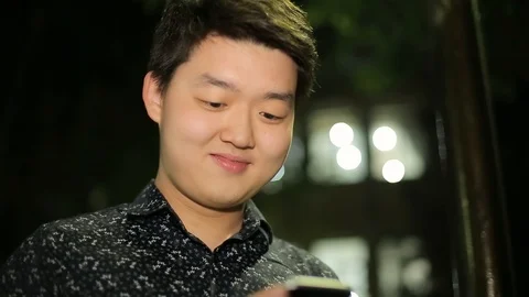 Man sms texting using app on smart phone at night in city. Stock Footage 90779528