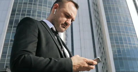 Man sms texting using app on smart phone in city. Handsome young businessman Stock Footage 92409443