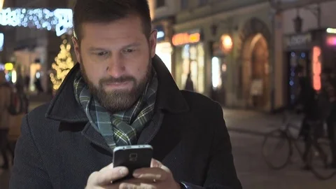 Man sms typing on smartphone app, night, christmas, steadycam Vidéo 72781990