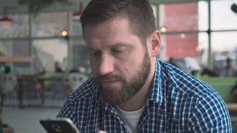 Man sms typing smartphone app, portrait, in cafe, close steadycam shot Vidéo 72952112