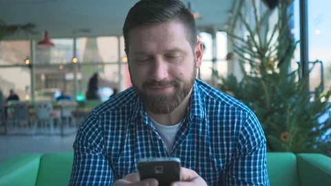 Man sms typing using smartphone app in cafe, portrait, close steadicam shot Vidéo 72946411