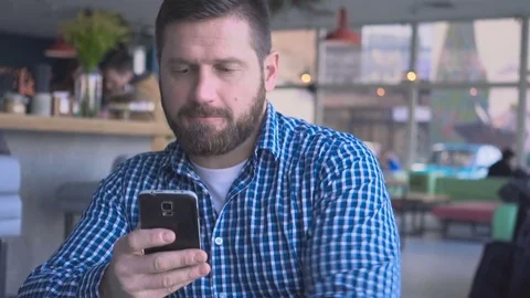 Man sms typing using smartphone app, cafe, portrait, steadicam shot  库存影片 72946959