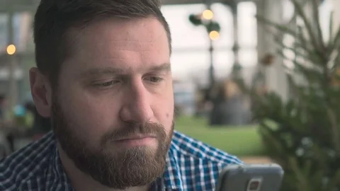 Man sms typing using smartphone app, portrait, in cafe, very close steadycam Vídeo Stock 72952251