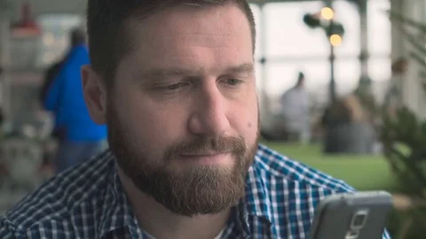 Man sms typing using smartphone app, look at camera, portrait, steadycam close Vidéo 72952254