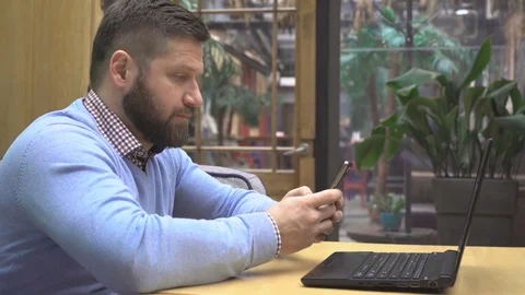 Man sms writing using app on smartphone, in pub, cafe, profile, steadycam shot 库存影片 73072572