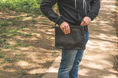 Man with snakeskin python handbag on nature background. 写真素材