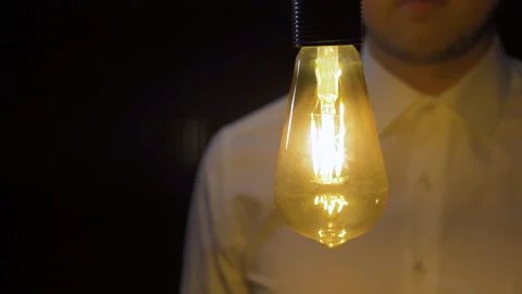 The man snapping his finger lights the bulb. Stock Footage 223829431