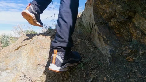 The man in the sneakers is climbing up the rocks. Close-UP. Slow Motion 库存影片 199192964
