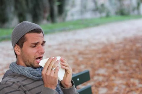 Man sneezing into tissue Stock Photos