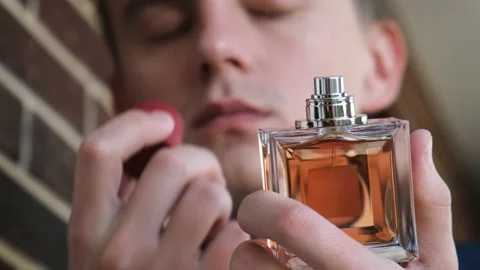 A man sniffs a bottle of perfume, close up Stock Footage 219727630