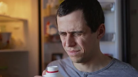 Man sniffs sour milk and grimaces Stock Footage 170882059