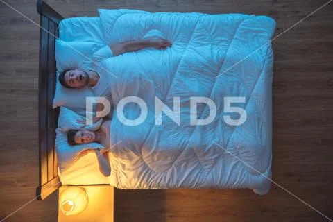 The man snore on the bed. evening night time. view from above Stock Photos