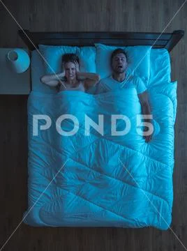 The man snore on the bed. evening night time. view from above Stock Photos