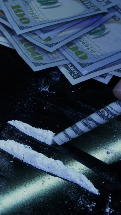 Man is snorting line of cocaine powder using rolled banknote. Vertical video 動画素材 335755517