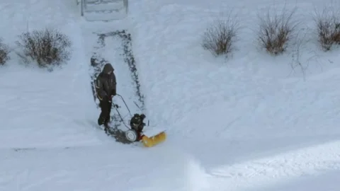A man with a snow blower cleaning footpaths Stock Footage 235156745