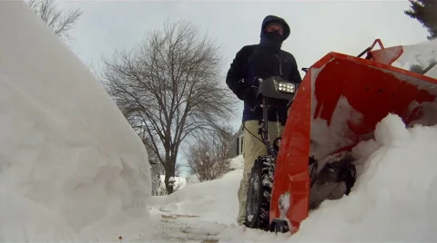 Man snow blowing low angle Stock Footage 47009624