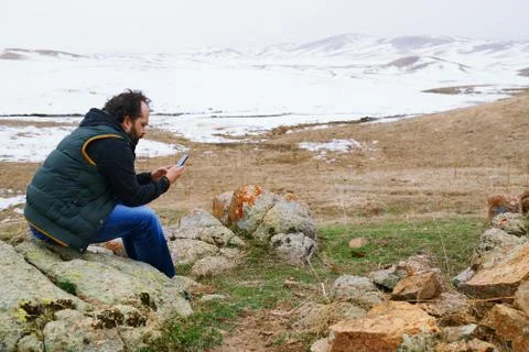 Man in snow landscape using GPS on his smartphone Stock Photos