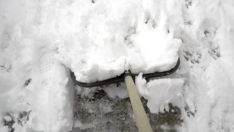 Man with snow shovel cleans sidewalks in winter Stock Footage 104082001