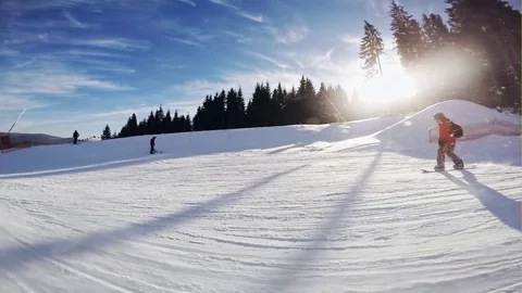 Man snowboarder slides down from the mountain in winter day, overlooking the Stock Footage 73296495