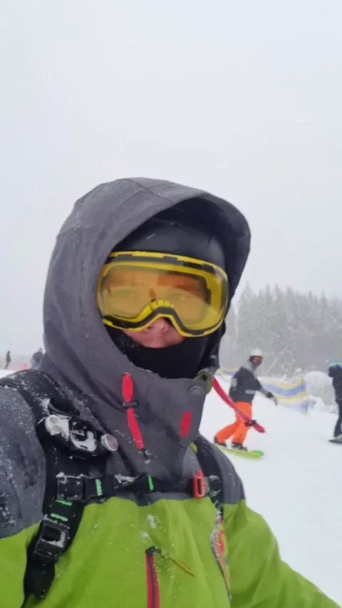 Man snowboarder taking selfie while going down by slope Stock Footage 219306902