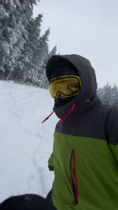 Man snowboarder taking selfie while sliding down by ski slope Stock Footage 235426070