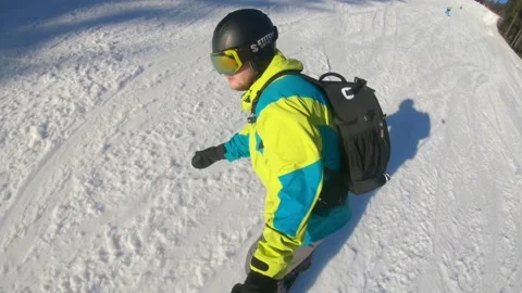 Man snowboarding down by hill taking selfie on action camera Video stock 144990164