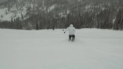 A man is snowboarding down a mountain. Stock Footage 131292083