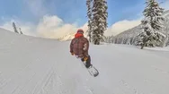 Man Snowboarding Down A Mountain Slope Stock Footage