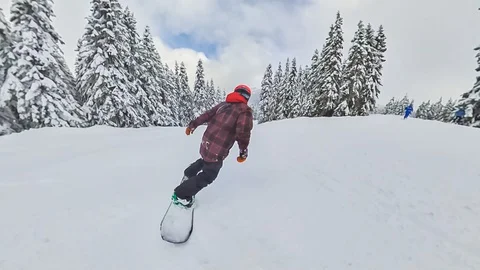 Man snowboarding down a mountain slope Stock Footage 124762658