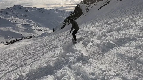 A man snowboarding down a mountain with some amazing clouds in the Stock Footage 109144152