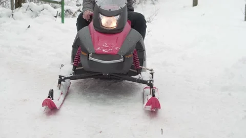 A man on the snowmobile puts forward gear and starts to move. Video stock 146709324