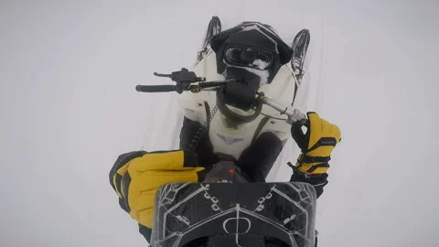 Man on a snowmobile rides and stops on the road adjusting his helmet Stock-Footage 102208599