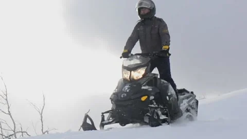 Man on a snowmobile rides down the slope Video stock 102212612