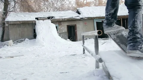 Man on snowskate slide on the rail Stock Footage 69788733