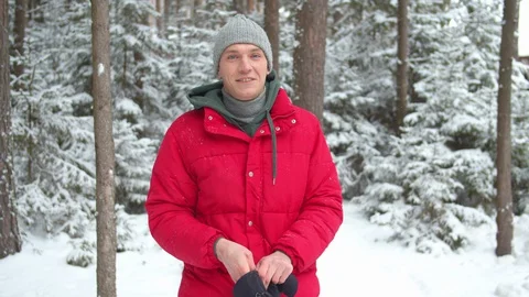 A man in a snowy forest puts on winter gloves Stock Footage 129098115