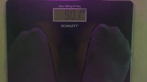 Man in socks stands on the scales Stock Footage 240723514