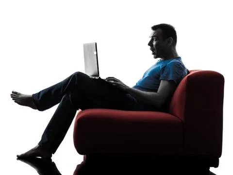 Man sofa couch computer computing laptop surprised Fotos Stock