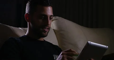 Man on sofa with digital tablet Video stock 62247603