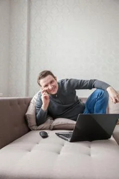 The man on a sofa with laptop Stock Photos