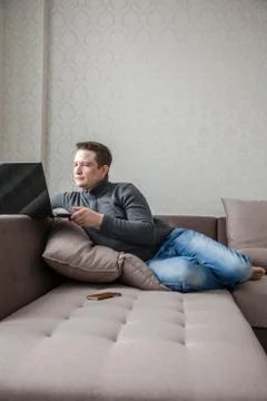 The man on a sofa with laptop Stock Photos