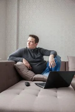 The man on a sofa with laptop Foto stock