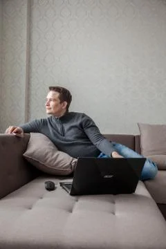 The man on a sofa with laptop Stock Photos